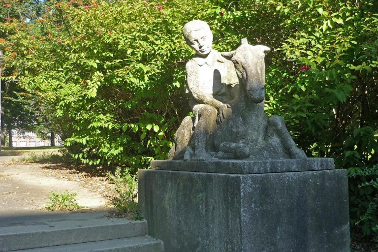 auf einem Sockel sitzt ein Junge auf einem Esel